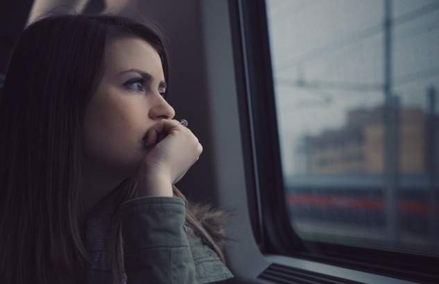 Young woman sitting in a train staring out the window. Image by StockSnap from Pixabay.&nbsp;